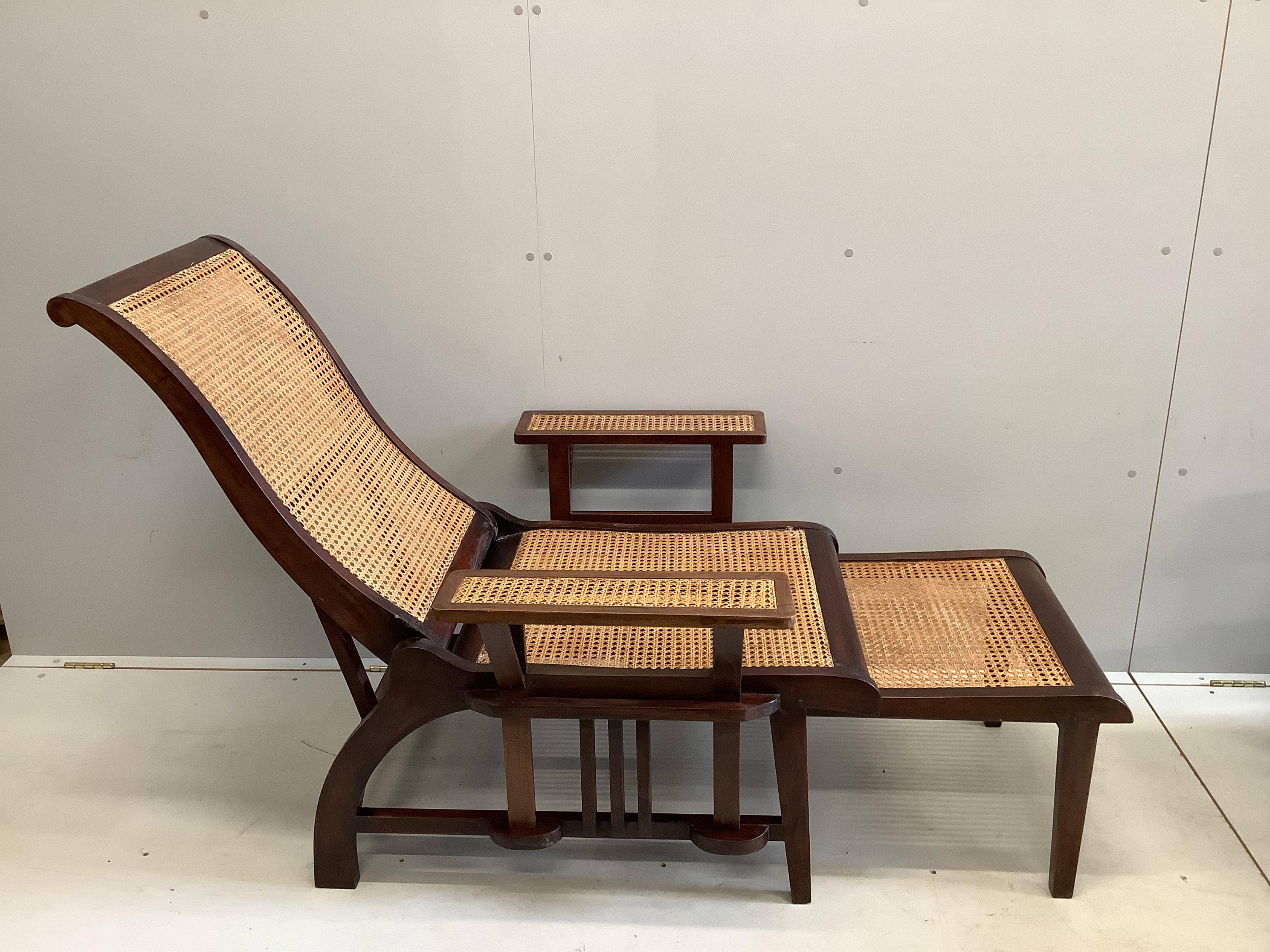 A pair of mid 20th century caned hardwood reclining garden chairs with integral sliding footrests and detachable armrests, width 85cm, depth 90cm, height 106cm. Condition - good